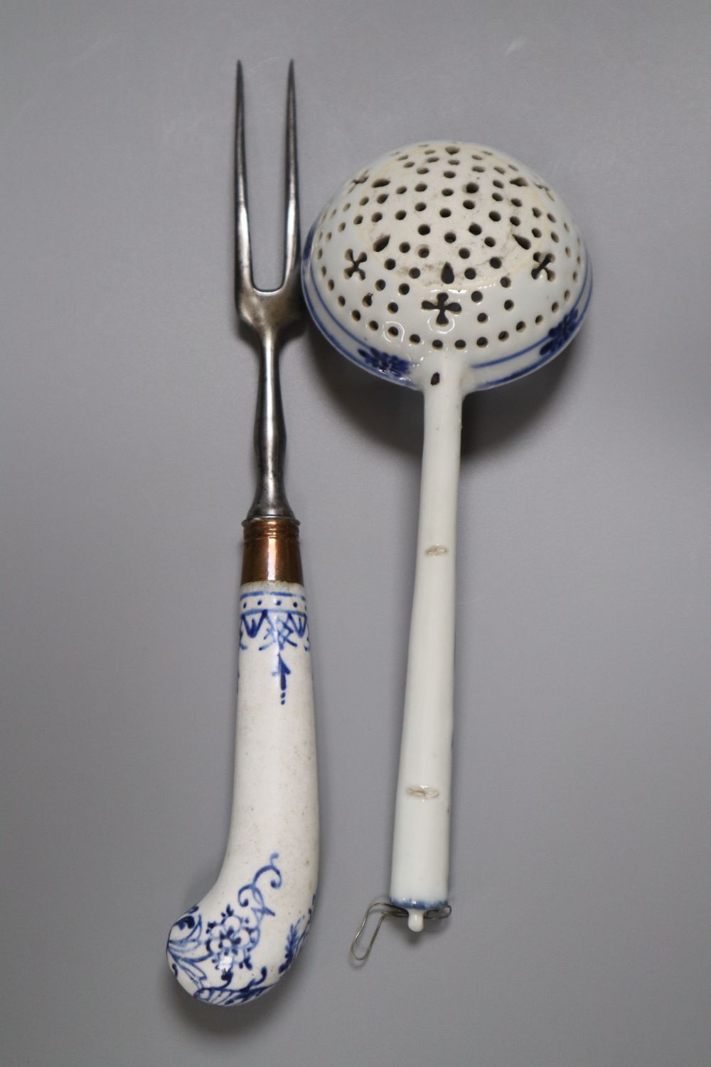 A Bow pistol grip blue and white handled fork, c.1770, 23cm, and a Continental porcelain blue and white strainer ladle, 17cm
